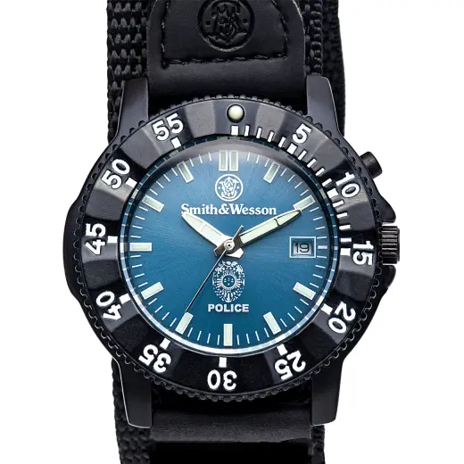 Policejní hodinky Smith & Wesson Smith & Wesson Police Watch. Tělo z nerezové oceli, otočná luneta, modrý ciferník s logem policie, datumový display, elektronické podsvícení, 3ATM, nylonový řemínek. Rozměr: 40 x 13 mm.