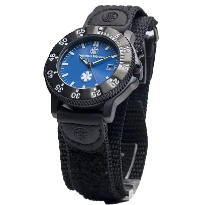 Smith &amp; Wesson EMT Watch. Tělo z nerezové oceli, otočná luneta, modrý ciferník s logem ZZS, datumový display, elektronické podsvícení, voděodolnost. 3ATM, nylonový řemínek. Rozměr: 40 x 13 mm.